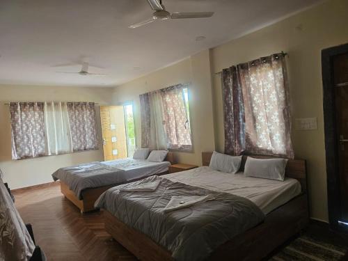 a bedroom with two beds and a couch at Hampi Rock-Inn in Hampi