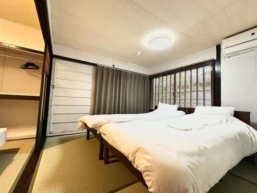 a bedroom with two beds and a window at 結莉の宿 高槻 in Takatsuki