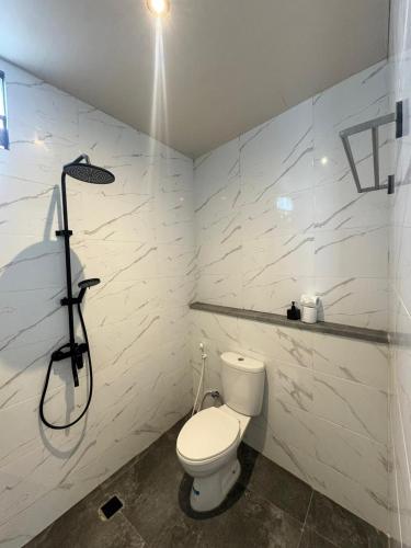 a bathroom with a toilet and a shower at Adi Bali Homestay in Uluwatu