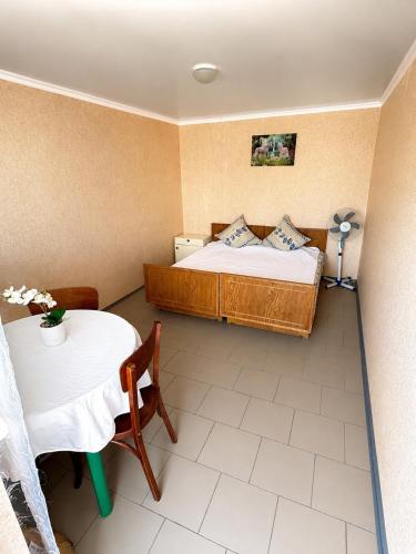 a bedroom with a bed and a table and a table and a bed at Novaya Dacha in Kurortne