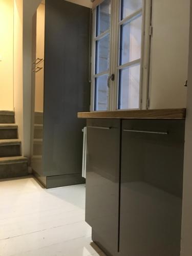 a kitchen with black cabinets and a window at Villa Des Ursulines in Bayeux