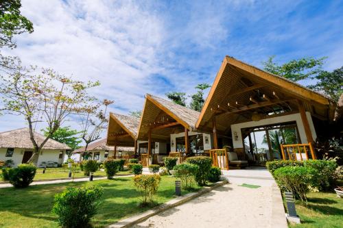 a building with a roof with a grass yard at Casa Verde Cliff Resort & Spa in Camotes Islands