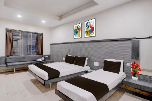 two beds in a hotel room with at Hotel O Kolhapur Gate Formerly Tanwani Lodging in Unchagao