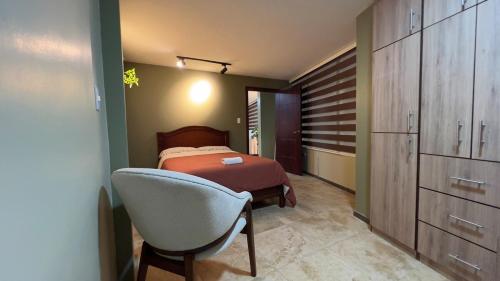 a bedroom with a bed and a chair in it at Spacious Suite privacy, and comfort in Riobamba