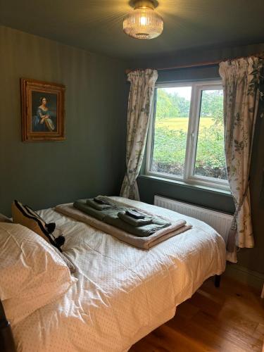 a bed in a room with a window and a blanket at Park Cottage cabin in Bix