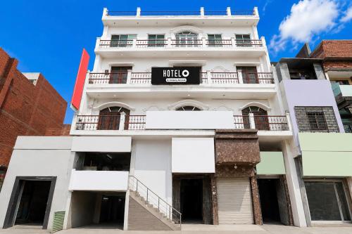 a white building with a sign on it at Super Hotel O Gaya Railway Station Formerly Vishal Inn in Gaya