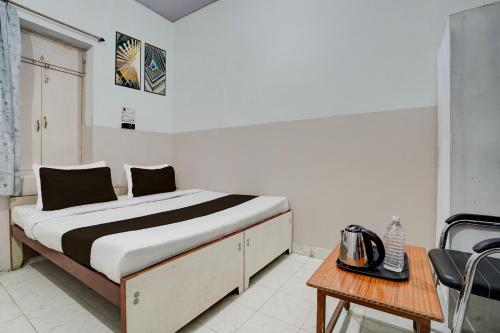 a bed in a room with a table and a chair at Super Hotel O Gaya Railway Station Formerly Vishal Inn in Gaya