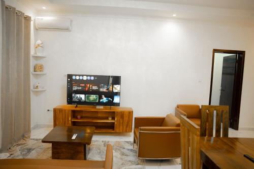 a living room with a couch and a tv at Appart Congo- Brazza - Av de la paix in Brazzaville