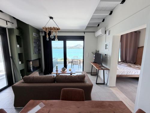 a living room with a couch and a view of the ocean at Ciel Seafront Suites - Maisonette in Lygia