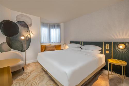 a bedroom with a large white bed and a desk at Hyatt Centric Reims in Reims