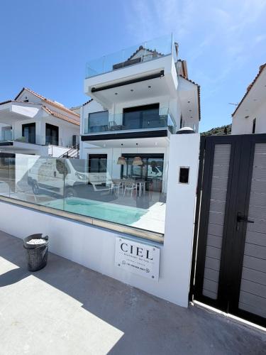 a large white house with a swimming pool at Ciel Seafront Suites - Maisonette in Lygia