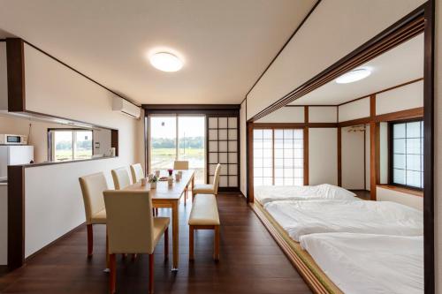 a room with a bed and a table and chairs at NASU den-en in Nasu