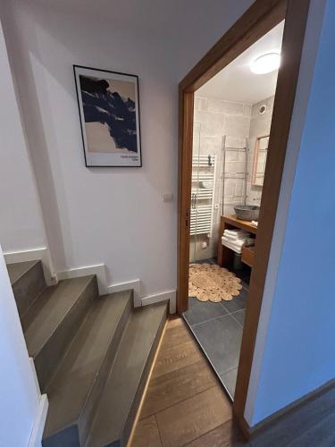 a hallway with stairs and a bathroom with a sink at Bastide le Petit Clos - les 2 Gîtes in Perpignan