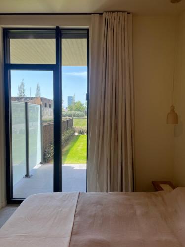 a bedroom with a bed and a large sliding glass door at Villa Rive in Ostend