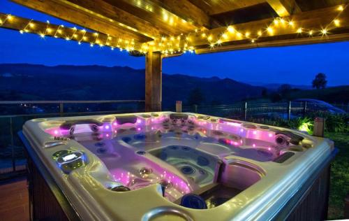 a jacuzzi tub with lights on a deck at OVIEDO REAL Spa in Oviedo