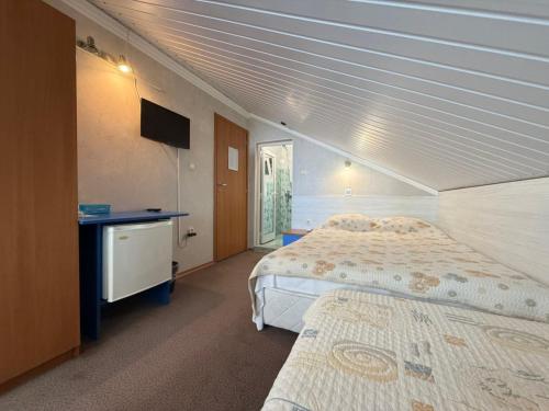 a bedroom with two beds and a desk and a television at Fresh Kiten in Kiten
