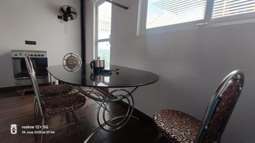 a table and chairs in a kitchen with a window at Tranquil Tents in Trivandrum
