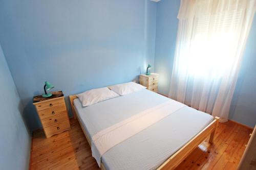 1 dormitorio con cama blanca y ventana en Apartment Laura en Tisno