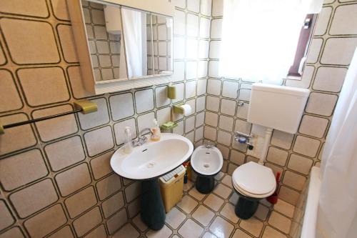 a small bathroom with a sink and a toilet at Apartment Laura in Tisno