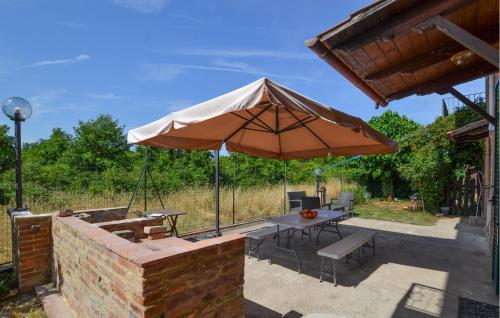 a patio with a table and an umbrella at Pet Friendly Home In Sinalunga in Sinalunga
