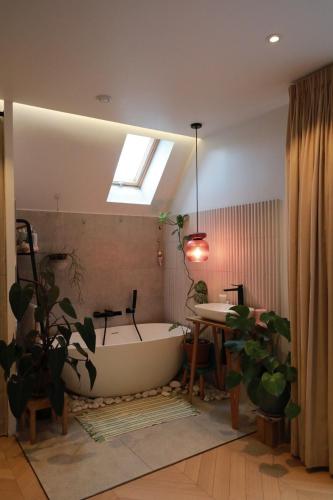 a bathroom with a tub and a sink and a table at The Gentle Stay in Brunoy