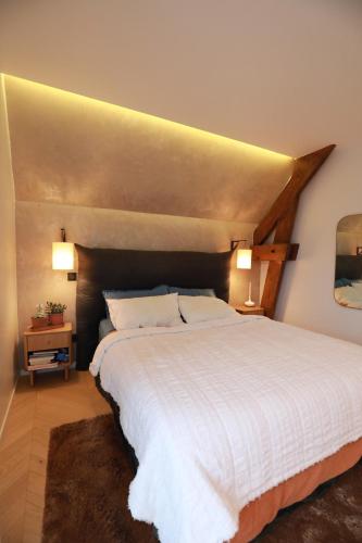a bedroom with a large white bed with two lamps at The Gentle Stay in Brunoy