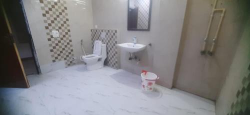 a bathroom with a toilet and a sink at ADA Residency in Noida