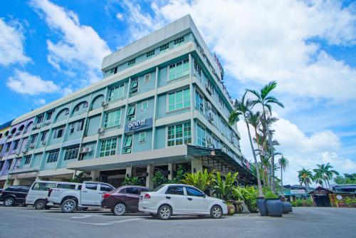 a large building with cars parked in front of it at Townhouse Near Tanjung Batu Formerly 900 Inn in Bintulu