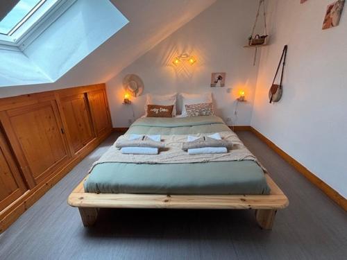 a bedroom with a large bed in a attic at Le Cocon Loire, 3-room apartment in La Ville-aux-Dames