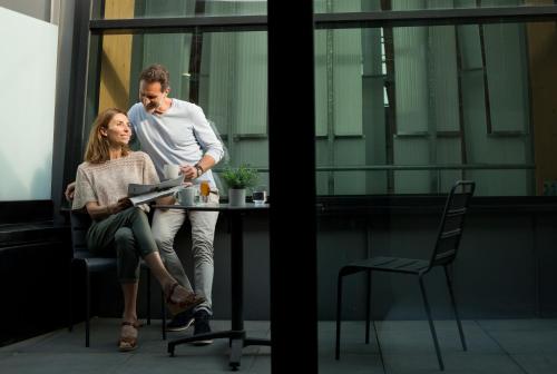 a man and a woman sitting at a table in an office at Villa Thermae Nancy in Nancy