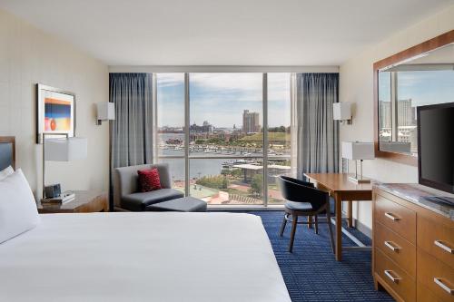 a hotel room with a bed and a desk and a room with a view at Hyatt Regency Baltimore in Baltimore