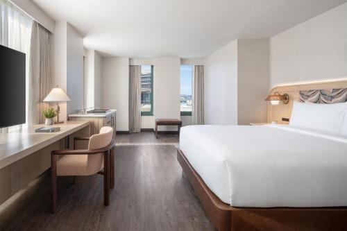 a hotel room with a large white bed and a desk at Hyatt Centric Fisherman's Wharf San Francisco in San Francisco