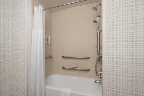 a bathroom with a shower with a white shower curtain at Hampton Inn & Suites Chadds Ford in Glen Mills