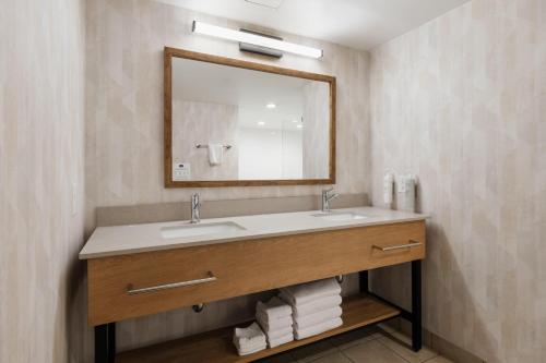 a bathroom with a sink and a mirror and towels at Hampton Inn Harbourgate in Myrtle Beach