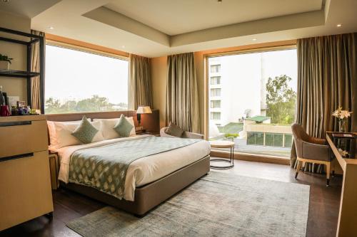 ein Hotelzimmer mit einem Bett und einem großen Fenster in der Unterkunft Indore Marriott Hotel in Indore