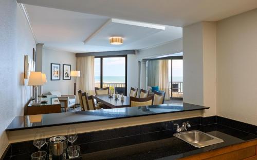 a kitchen with a sink and a living room at Hilton Beachfront Resort & Spa Hilton Head Island in Hilton Head Island