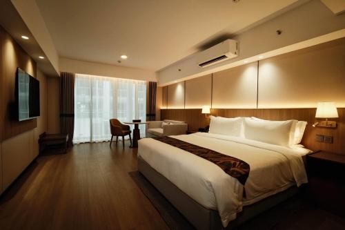 a hotel room with a large bed and a table at Wyndham Garden Manila Bay in Manila