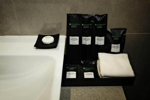 a bathroom with a sink and towels and a bath tub at Wyndham Garden Manila Bay in Manila