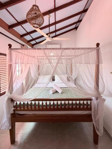 a bed in a room with a mosquito net at Soulinn Regina Weligama in Weligama