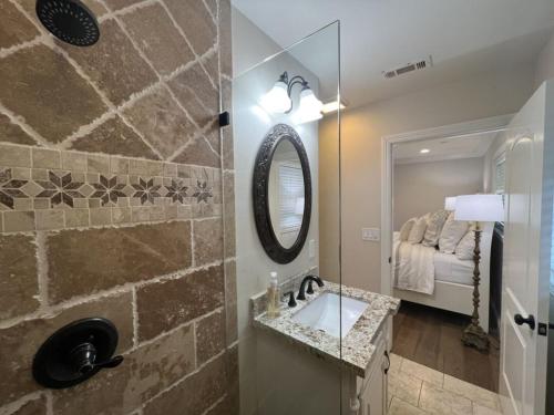 a bathroom with a sink and a mirror and a bed at Fantastic 6 bedroom, 4 & Half bath home (4 master Suites), pool home in Anaheim