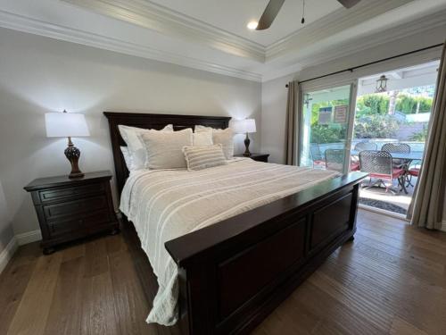a bedroom with a large bed and a large window at Fantastic 6 bedroom, 4 & Half bath home (4 master Suites), pool home in Anaheim