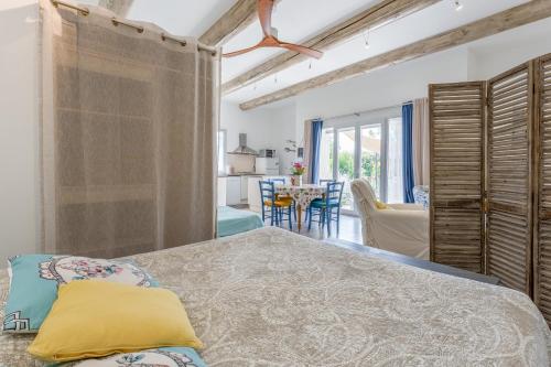 a bedroom with a bed and a dining room at Gîte le Petit Luberon - Lisianthus in Cabrières-dʼAvignon