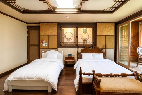 two beds in a room with two windows at Jeju Nine resort in Jeju