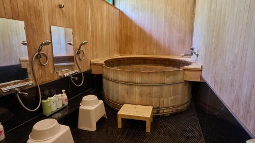 a bathroom with a large wooden tub and a toilet at Shinwaso Kaishin in Amakusa