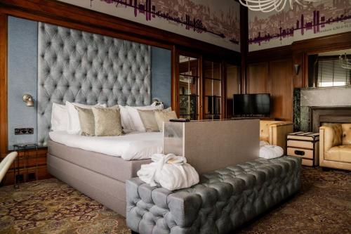 a bedroom with a large bed with a tufted headboard at Hotel New York by WestCord in Rotterdam