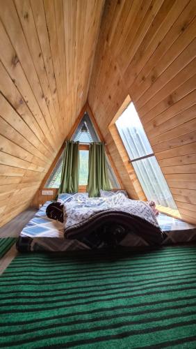 a bedroom with a bed in a wooden room at skytouch Lambri pass view Jibhi in Jibhi