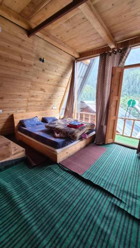 a bedroom with a bed in a wooden room at skytouch Lambri pass view Jibhi in Jibhi