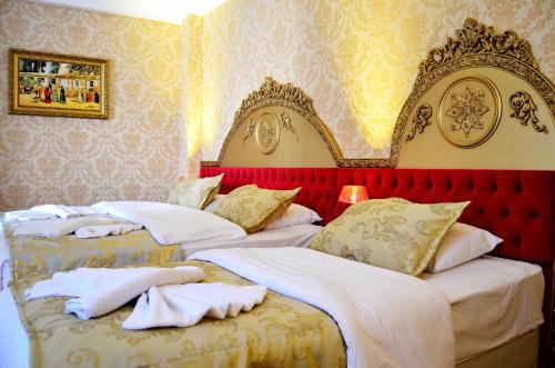 - 2 lits dans une chambre avec une tête de lit rouge dans l'établissement Balin Hotel - Special Category, à Istanbul