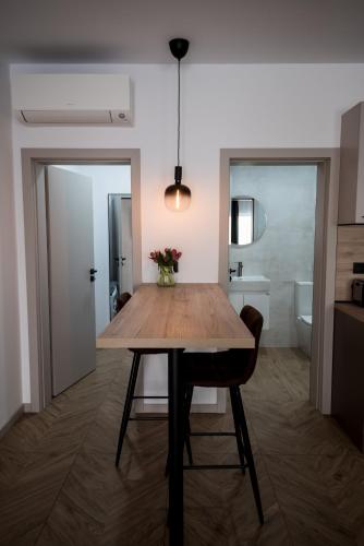 a dining room with a wooden table and a bathroom at Incanto Rentals in Silistra