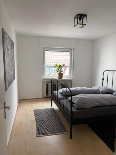 two beds in a white room with a window at Village Apartment Rheinbreitbach in Rheinbreitbach